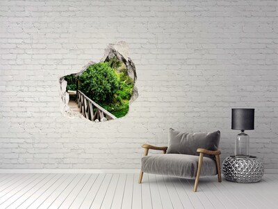 Vinilo adhesivo efecto agujero 3d para casa Un paraíso verde con un puente de madera.
