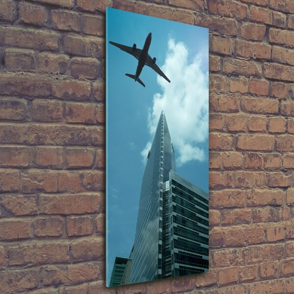 Cuadro decorativo en cristal con canto pulido vertical Un avión sobre la ciudad
