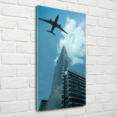Cuadro decorativo en cristal con canto pulido vertical Un avión sobre la ciudad
