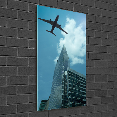 Cuadro decorativo en cristal con canto pulido vertical Un avión sobre la ciudad