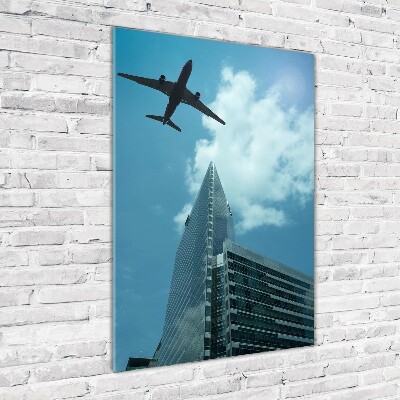 Cuadro decorativo en cristal con canto pulido vertical Un avión sobre la ciudad