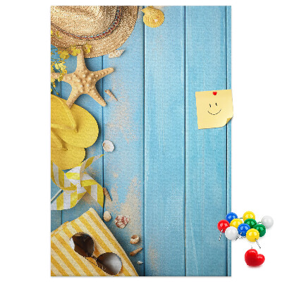 Decoración pizarra de corcho Accesorios de verano sobre un fondo de madera azul.