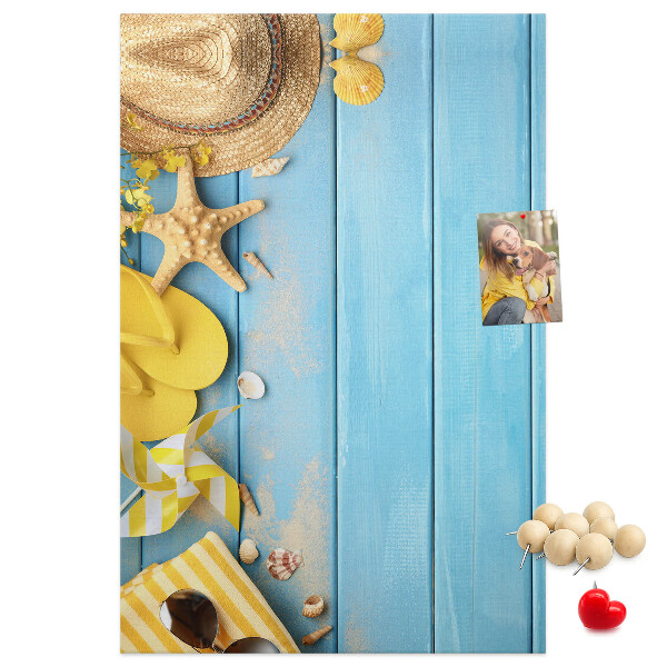Decoración pizarra de corcho Accesorios de verano sobre un fondo de madera azul.