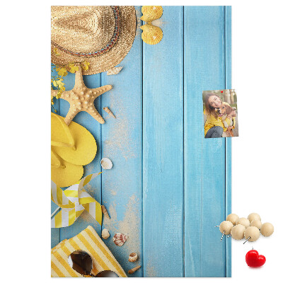 Decoración pizarra de corcho Accesorios de verano sobre un fondo de madera azul.