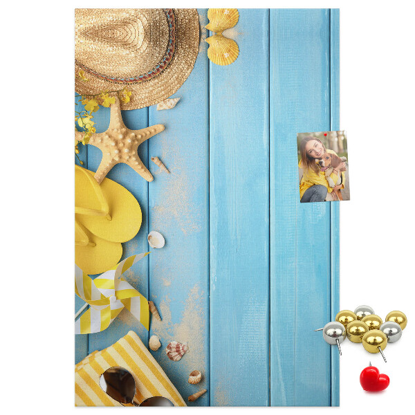 Decoración pizarra de corcho Accesorios de verano sobre un fondo de madera azul.