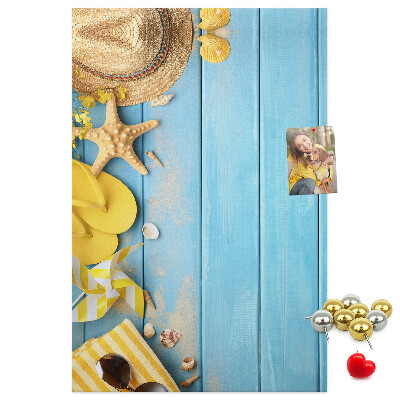 Decoración pizarra de corcho Accesorios de verano sobre un fondo de madera azul.