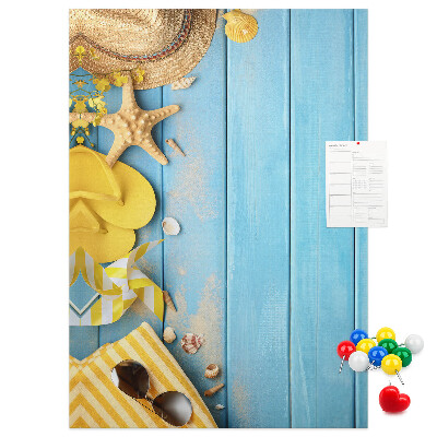 Decoración pizarra de corcho Accesorios de verano sobre un fondo de madera azul.