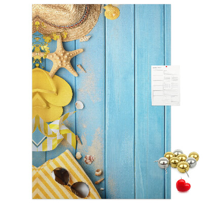 Decoración pizarra de corcho Accesorios de verano sobre un fondo de madera azul.
