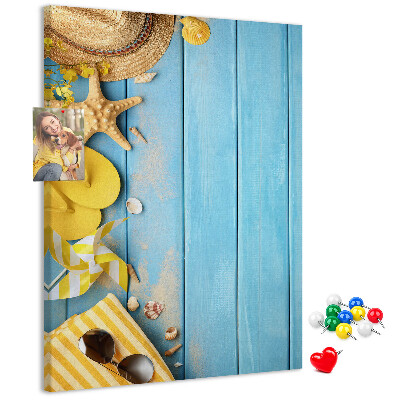 Decoración pizarra de corcho Accesorios de verano sobre un fondo de madera azul.