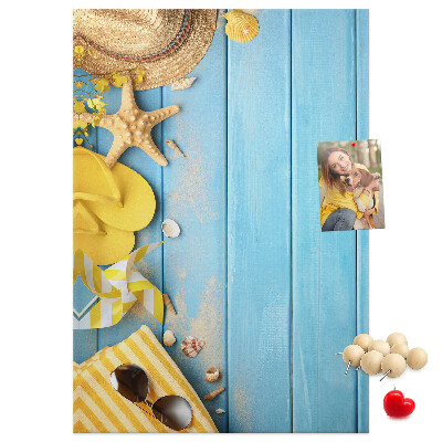 Decoración pizarra de corcho Accesorios de verano sobre un fondo de madera azul.