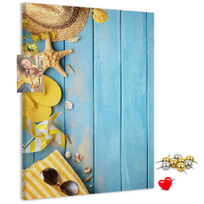 Decoración pizarra de corcho Accesorios de verano sobre un fondo de madera azul.