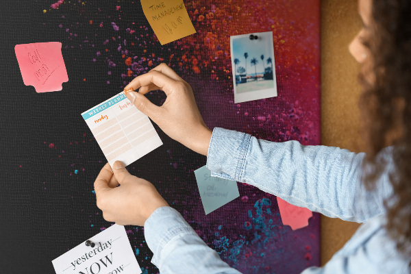 Pizarra de corcho decorativa con diseño de explosiones coloridas sobre fondo negro