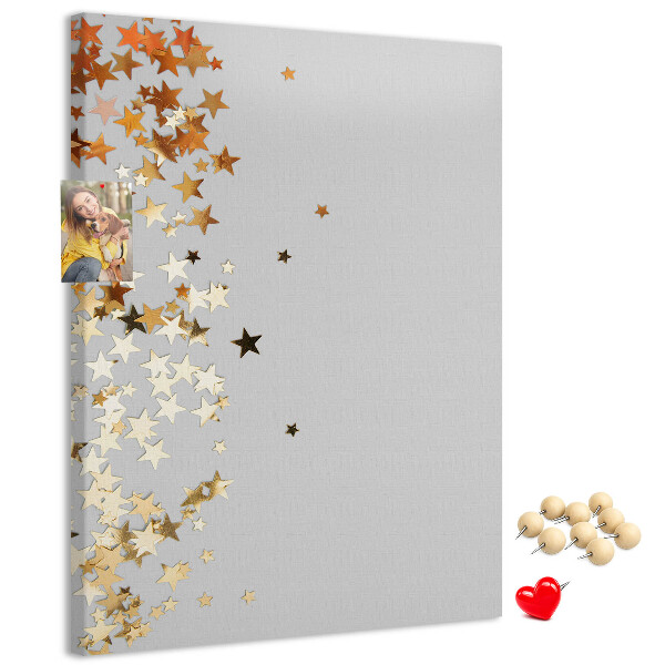 Tablón de corcho Estrellas doradas y plateadas sobre fondo gris.