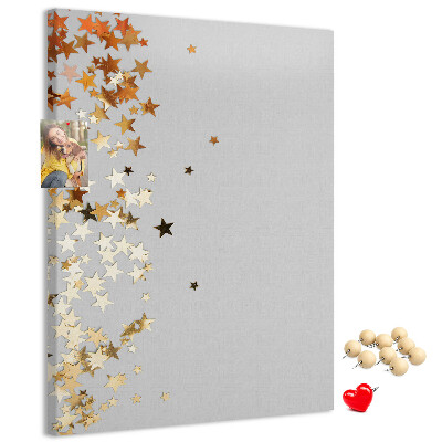 Tablón de corcho Estrellas doradas y plateadas sobre fondo gris.