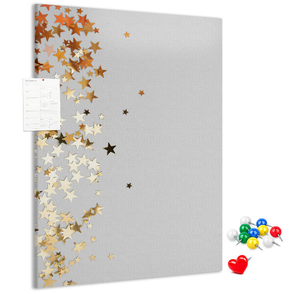 Tablón de corcho Estrellas doradas y plateadas sobre fondo gris.