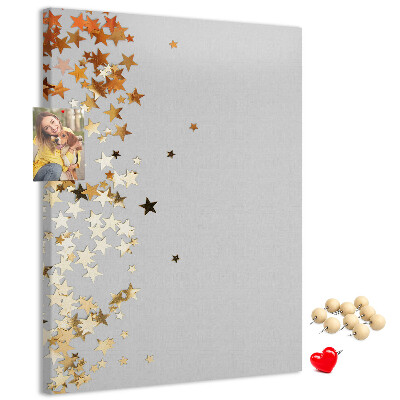Tablón de corcho Estrellas doradas y plateadas sobre fondo gris.