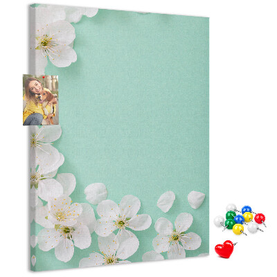 Pizarra de corcho decorativa con detalles florales sobre un fondo pastel