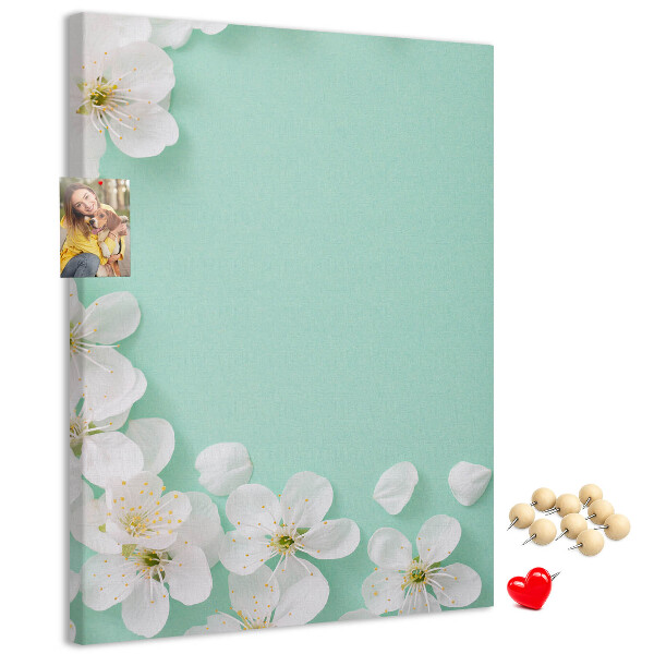 Pizarra de corcho decorativa con detalles florales sobre un fondo pastel