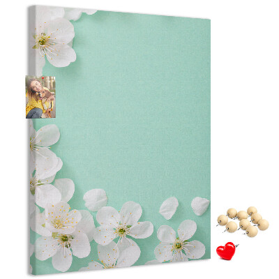 Pizarra de corcho decorativa con detalles florales sobre un fondo pastel