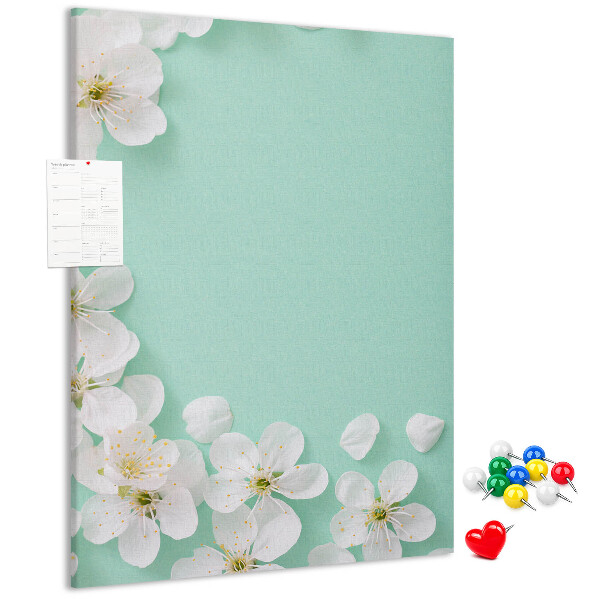 Pizarra de corcho decorativa con detalles florales sobre un fondo pastel