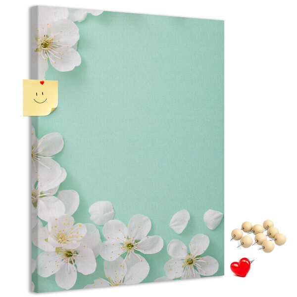 Pizarra de corcho decorativa con detalles florales sobre un fondo pastel