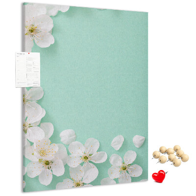 Pizarra de corcho decorativa con detalles florales sobre un fondo pastel