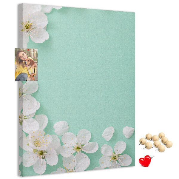 Pizarra de corcho decorativa con detalles florales sobre un fondo pastel