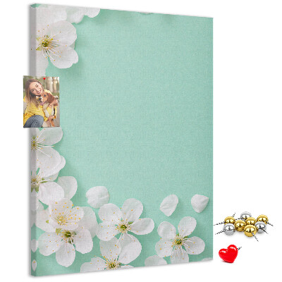 Pizarra de corcho decorativa con detalles florales sobre un fondo pastel