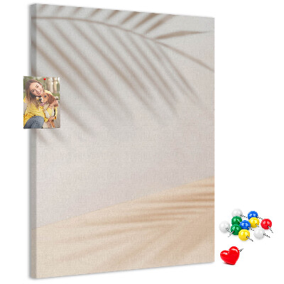 Pizarra de corcho decorativa con delicadas sombras de palmeras sobre un fondo claro