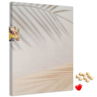 Pizarra de corcho decorativa con delicadas sombras de palmeras sobre un fondo claro