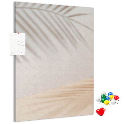 Pizarra de corcho decorativa con delicadas sombras de palmeras sobre un fondo claro