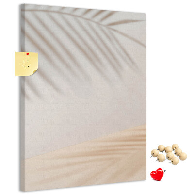Pizarra de corcho decorativa con delicadas sombras de palmeras sobre un fondo claro