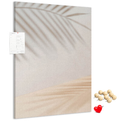Pizarra de corcho decorativa con delicadas sombras de palmeras sobre un fondo claro