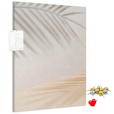 Pizarra de corcho decorativa con delicadas sombras de palmeras sobre un fondo claro