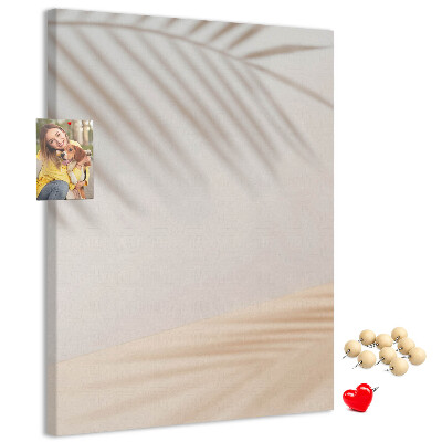 Pizarra de corcho decorativa con delicadas sombras de palmeras sobre un fondo claro