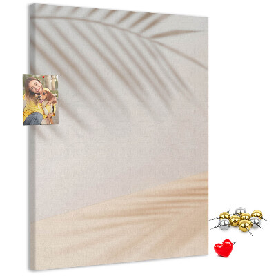 Pizarra de corcho decorativa con delicadas sombras de palmeras sobre un fondo claro