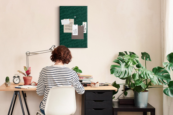 Pizarra de corcho decorativa con diseño de hojas sobre fondo verde oscuro