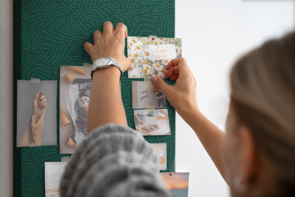 Pizarra de corcho decorativa con diseño de hojas sobre fondo verde oscuro