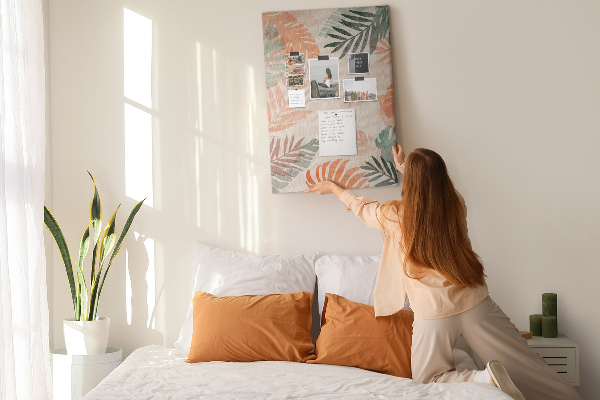 Pizarra de corcho decorativa con diseño de hojas tropicales en tonos suaves