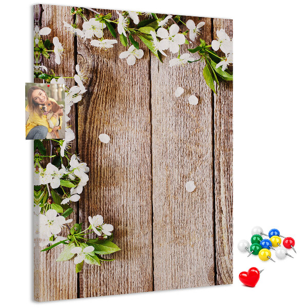 Tablero de corcho con diseño de flores sobre fondo de madera