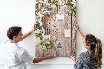 Tablero de corcho con diseño de flores sobre fondo de madera