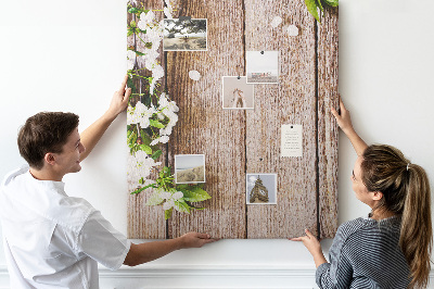 Tablero de corcho con diseño de flores sobre fondo de madera