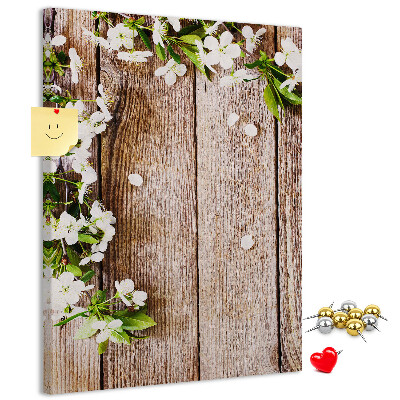 Tablero de corcho con diseño de flores sobre fondo de madera