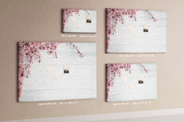 Tablero de corcho decorado con diseño de ramas florales sobre fondo de madera blanca