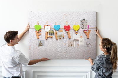 Pizarra de corcho con diseño de corazones familiares sobre fondo de madera