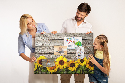 Tablero de corcho decorado con diseño de girasoles sobre fondo de tablas de madera