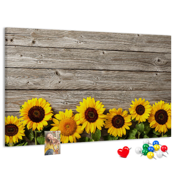 Tablero de corcho decorado con diseño de girasoles sobre fondo de tablas de madera