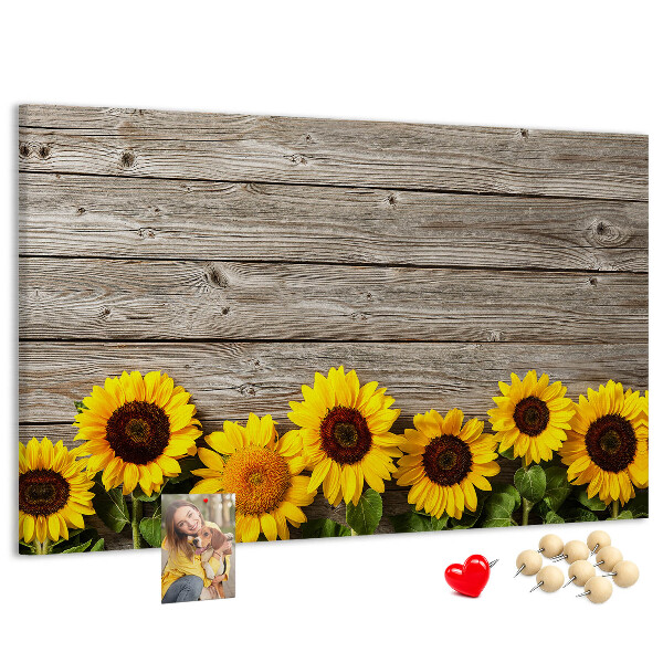Tablero de corcho decorado con diseño de girasoles sobre fondo de tablas de madera