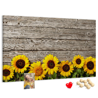 Tablero de corcho decorado con diseño de girasoles sobre fondo de tablas de madera
