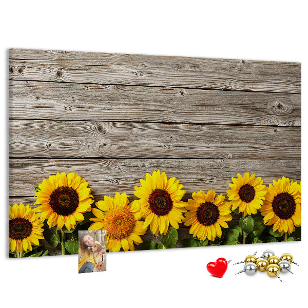 Tablero de corcho decorado con diseño de girasoles sobre fondo de tablas de madera